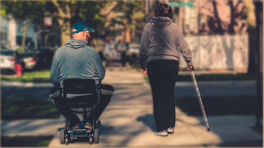 a person in a wheelchair and a person walking down the street