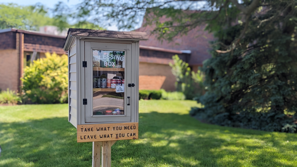 a blessing box with a sign on it that reads "take what you need. leave what you can."